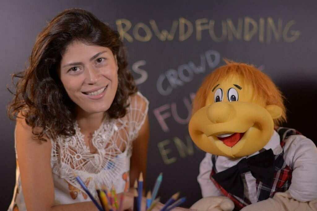 Teacher Camila e o boneco Dedé em ação, durante a videoaula.
