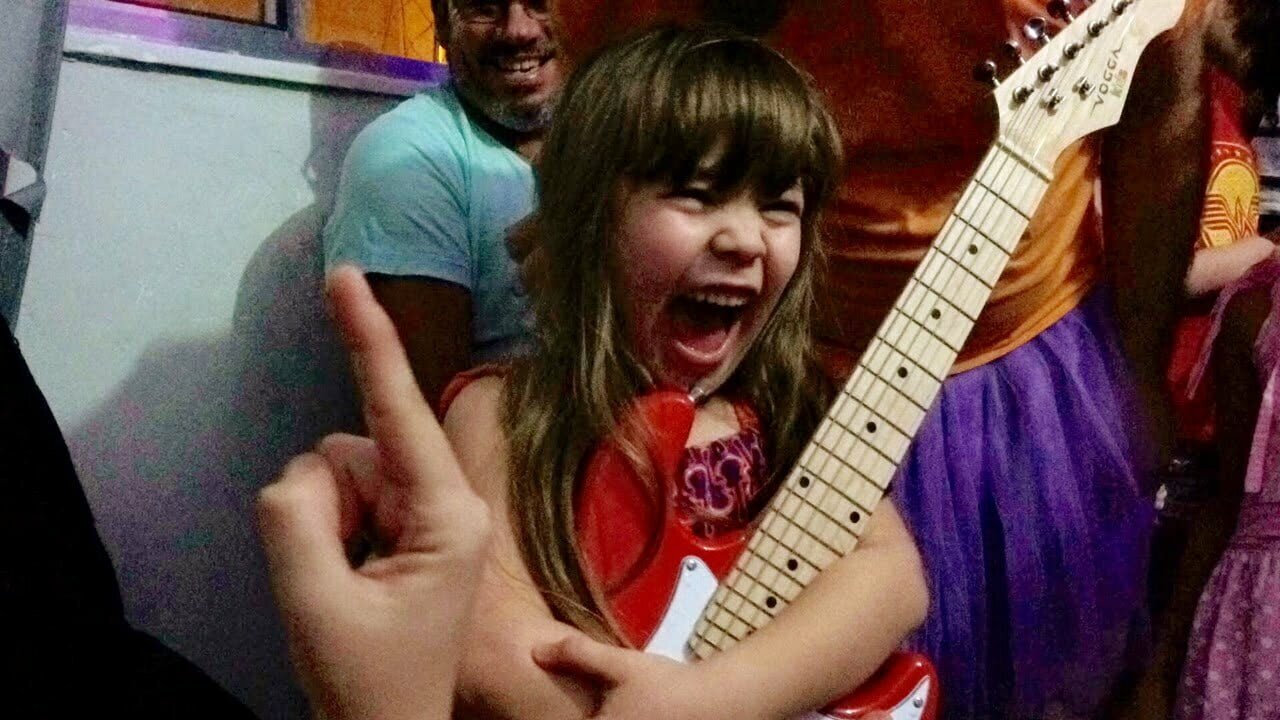 Lucia e sua guitarra, sonho conquistado por meio do site Lâmpada Mágica.