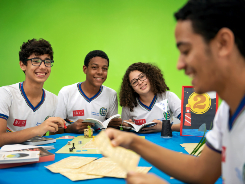 Alunos da escola do NAVE interagem em mesa com jogos.