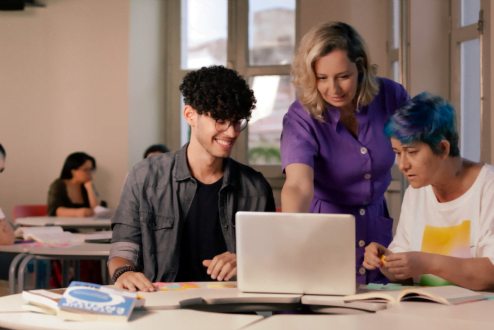 Estudantes trabalham junto à professora em computador, na CESAR School.